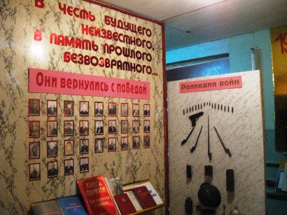 Egy 1976-ban alapított iskolamúzeum Nagy Honvédő Háborúról szóló tablói. Urazgildi, Baskortosztan, 2013. Feliratok: Az ismeretlen jövő tiszteletére – A vissza nem térő múlt emlékére, Győzelemmel tértek vissza, A háború relikviái