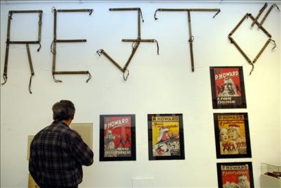 Egy érdeklődő nézegeti a Rejtő Jenő regényeinek címlapjait ábrázoló plakátokat a Zsidó Múzeumban P. Howard - Rejtő Jenő legendás élete című kiállításon