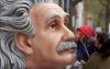 Egy gyermek, amint puszit nyom Einstein orrára egy londoni kiállításon