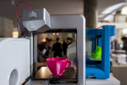 Egy otthoni 3D nyomtató és egy azzal készült műanyag csésze