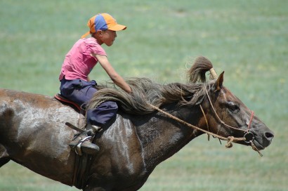 Ennek a lóversenyző mongol kisfiúnak már elér a kengyelig a lába, mégsem felnőtt