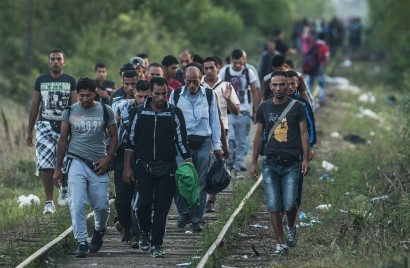 „Illegális bevándorlók a Röszke melletti vasúti átjárónál, a magyar-szerb határon 2015. augusztus 25-én” (MTI)